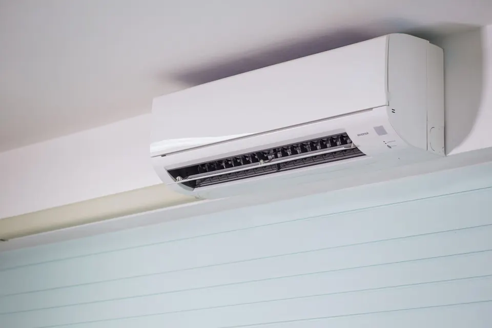 Witte airco aan het plafond van een kamer